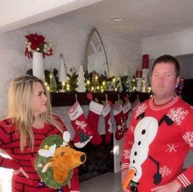 Ugly Christmas sweatshirts from Halloween Costumes. She's wearing a 3-D rudolf jumper. He's wearing a snowman sweater with 3D carrot and baubles.